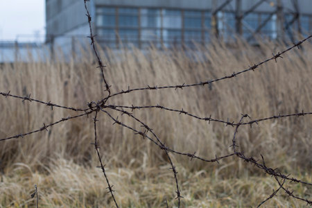 Industrial sad autumn urban landscape with abadoned buildings and old barbed wire