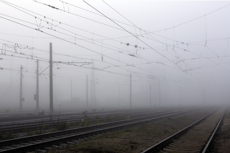 Crossing railways disappearing in the mist in autumn morningの写真素材