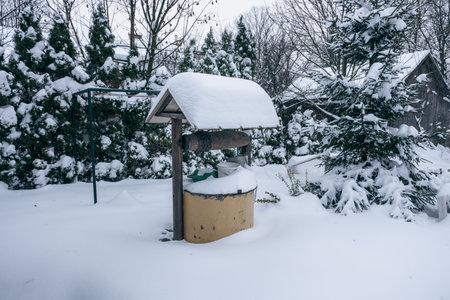 A snowy well - a large snow cap in the yardの写真素材