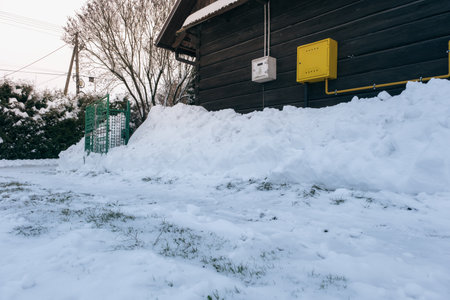 Gas and electricity box on a wooden house among the snowの写真素材