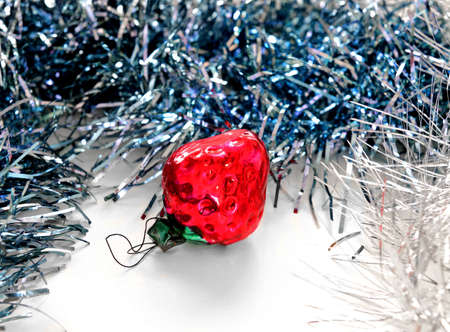 Vintage Christmas toy (strawberry) among glittering tinselの写真素材