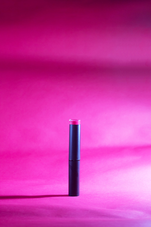 Red lipstick with spot lighting on red background,shallow Depth of Field,Focus on lipstick.の写真素材