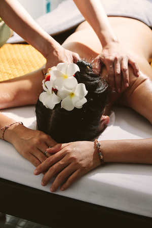 Beautiful woman having a wellness back massage,Shallow depth of field with focus on arm.の写真素材