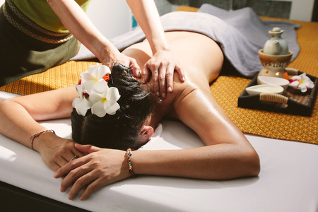 Beautiful woman having a wellness back massage,Shallow depth of field with focus on arm.の写真素材