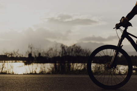 Blurred silhouette of people Image of sporty company on bicycles outdoors against sunset motion.の写真素材