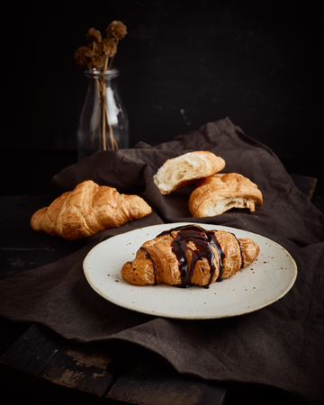 Croissant decorated with chocolate sauce.の写真素材