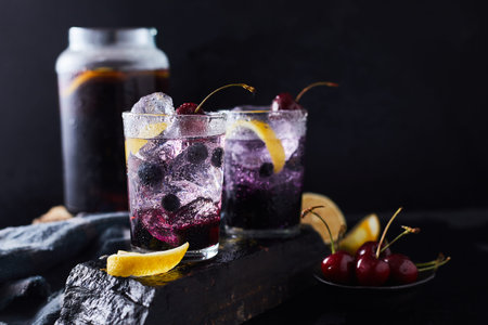 Fresh blueberry cocktail with lemon peel and cherry.の写真素材