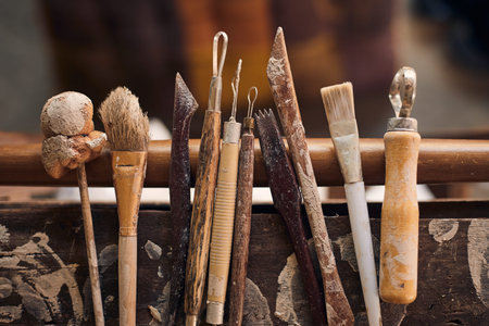 Tools for forming clay on  wooden background.