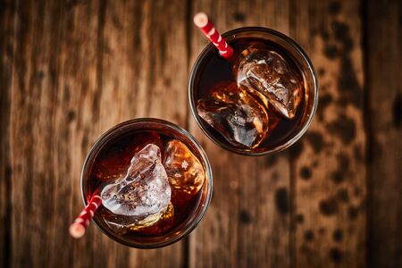 Close up glass of refreshing cola with ice on table.の写真素材