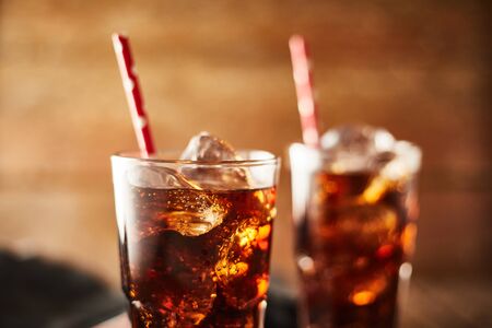 Close up glass of refreshing cola with ice on table.の写真素材