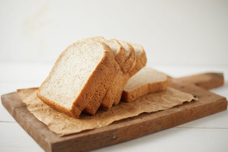 Whole wheat bread baked on wooden background.