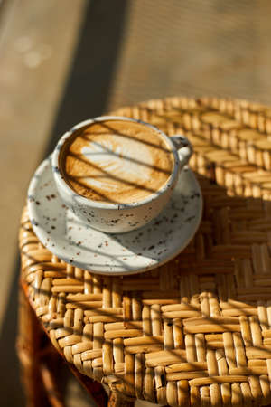 Selective focus cup of hot latte art coffee on wooden table,focus at white foamの写真素材
