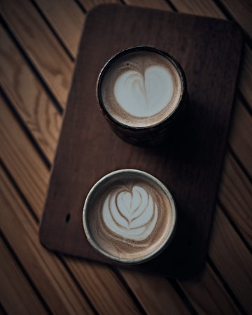 Selective focus cup of hot latte art coffee on wooden table,focus at white foamの写真素材