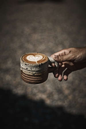 Man holding coffee cup with latte art, Selective focusの写真素材