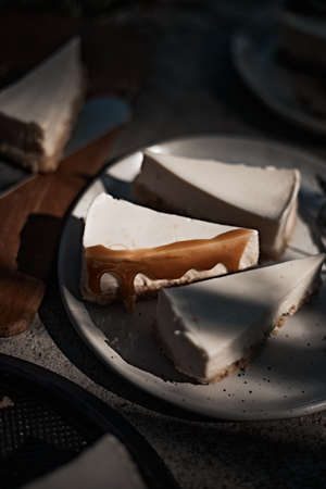 Slice of cheesecake with caramel sauce on plate.の写真素材