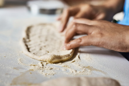 Hands knead dough to make a pizza, selective focusの写真素材