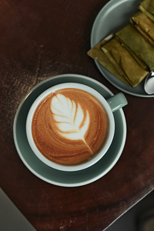 Selective focus cup of hot latte art coffee on wooden table,focus at white foamの写真素材