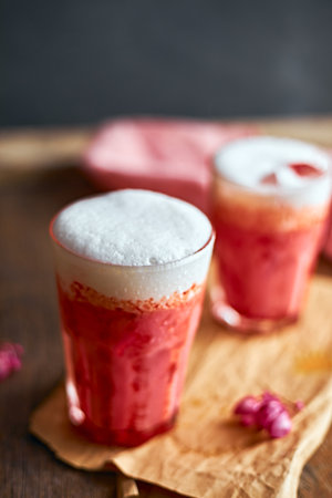 Thai style iced pink milk.Cold sweet drink Red Grenadien Sugar Syrup mix with milk and iced cube in glass, selective focusの写真素材