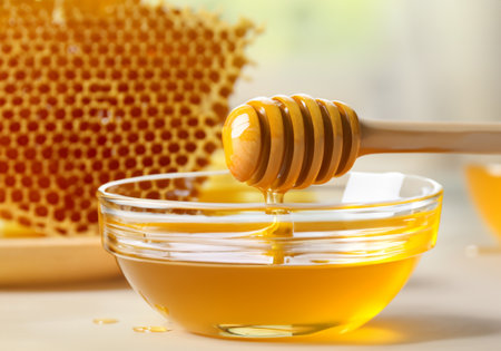 Honey dipper and honeycomb on tableの素材