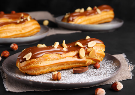 Chocolate eclairs with calamelized nuts, on dark backgroundの素材