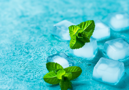 Ice cubes and mint on a blue background, selective focusの素材
