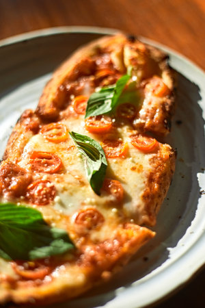 Sliced and served Italian pizza Margherita with basil leaves ,selective focusの写真素材