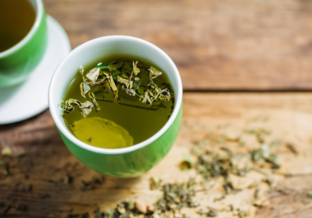 Hot steaming black tea in a cup on a rustic backgroundの素材