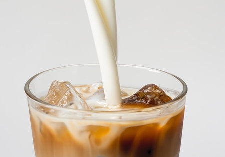 Milk poured over Iced Coffee on white backgroundの素材