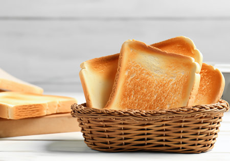 Toast bread in basket on white wooden table, blur backgroundの素材