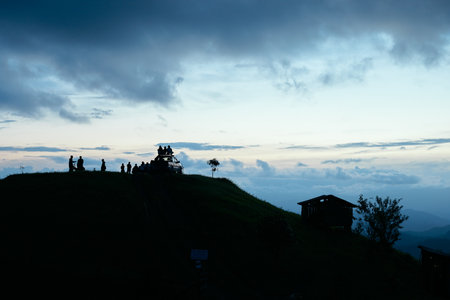 Silhouette of the person on the high mountainÂ at sunset.の写真素材