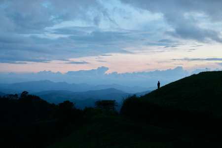 Silhouette of the person on the high mountainÂ at sunset.の写真素材