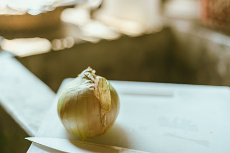 Close up fresh onion with peel on cutting board.の写真素材