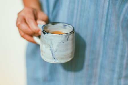 A female hand holding a cup of espresso shot.の写真素材