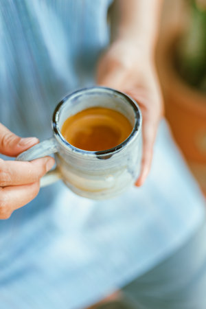 A female hand holding a cup of espresso shot.の写真素材