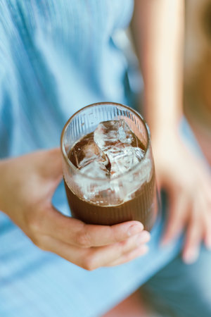 Close up of Hand holding a glass of Iced Americano or back coffeeの写真素材