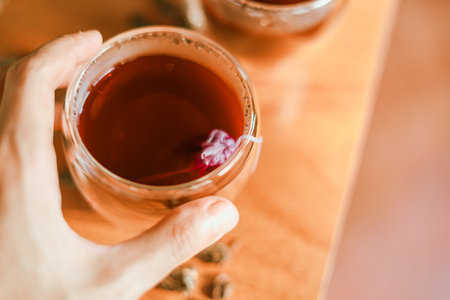 Red tea in the small clear glass on wooden tableの写真素材