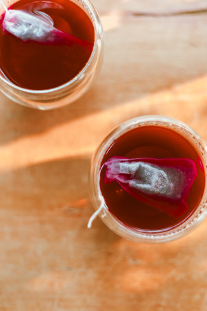 Red tea in the small clear glass on wooden tableの写真素材