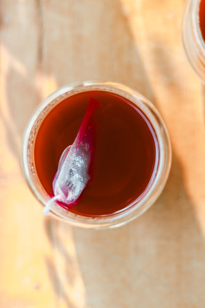 Red tea in the small clear glass on wooden tableの写真素材