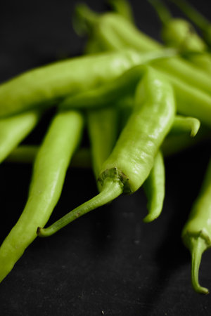 Fresh green chilli on a black background.の写真素材