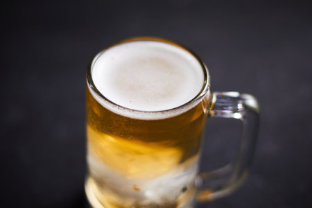 Close up mug of beer on wooden tableの写真素材