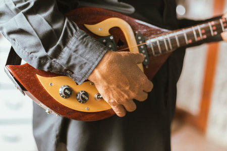 Close up hand playing Thai Mandolin, Phin in home studio.の写真素材
