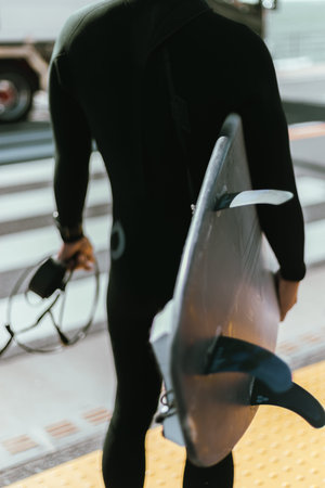 View of man walking with surfing board.