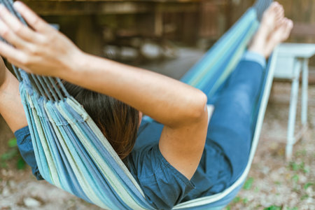 Happy young woman relaxing in a hammock in the gardenの写真素材