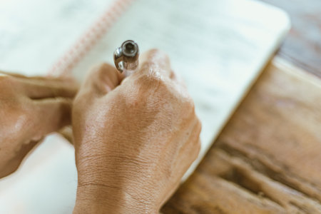 A hand writing on a notebook on a table, selective focusの写真素材