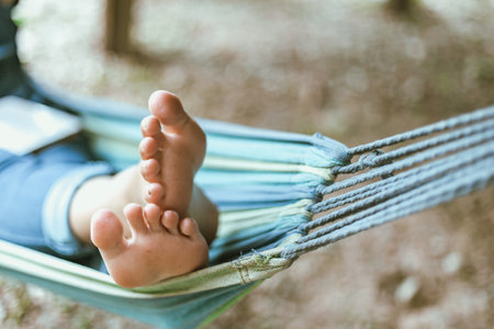 Happy young woman relaxing in a hammock in the gardenの写真素材