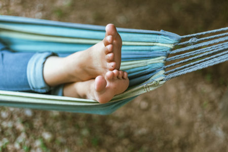 Happy young woman relaxing in a hammock in the gardenの写真素材