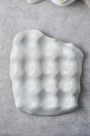 Close up ceramic tray for jewelry on gray background.