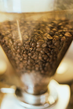 Fresh roasted coffee bean in a coffee grinder at Cafeの写真素材