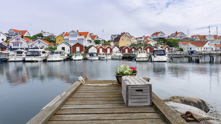 Ockero, Sweden - June 10, 2021: A pier with wooden box and flowerpot with blooming flowers at the...