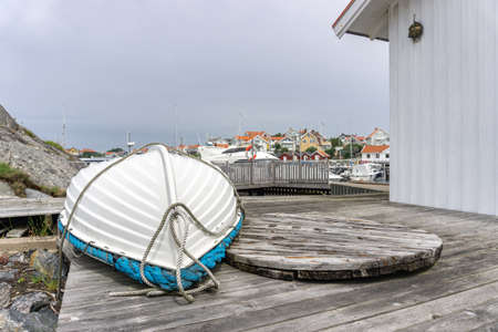 Ockero, Sweden - June 10, 2021: White wooden boat with blue detail turned up and down awaiting summer seasonのeditorial素材